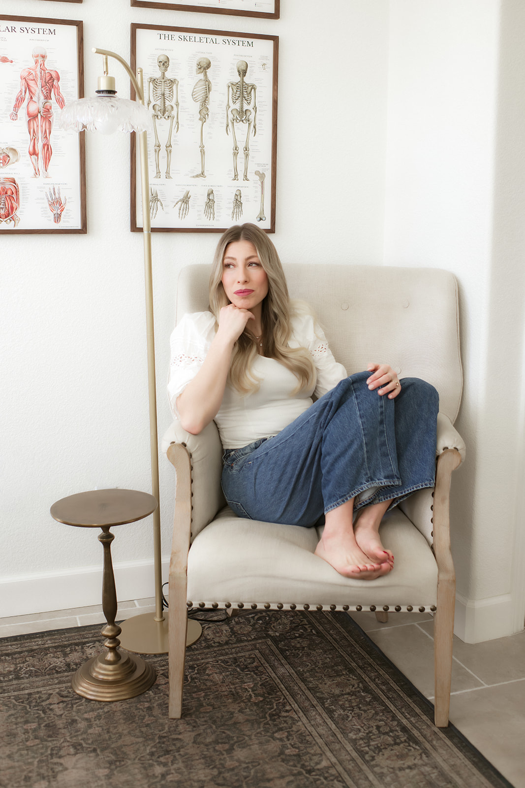 Brooke seated pensively in her cream armchair